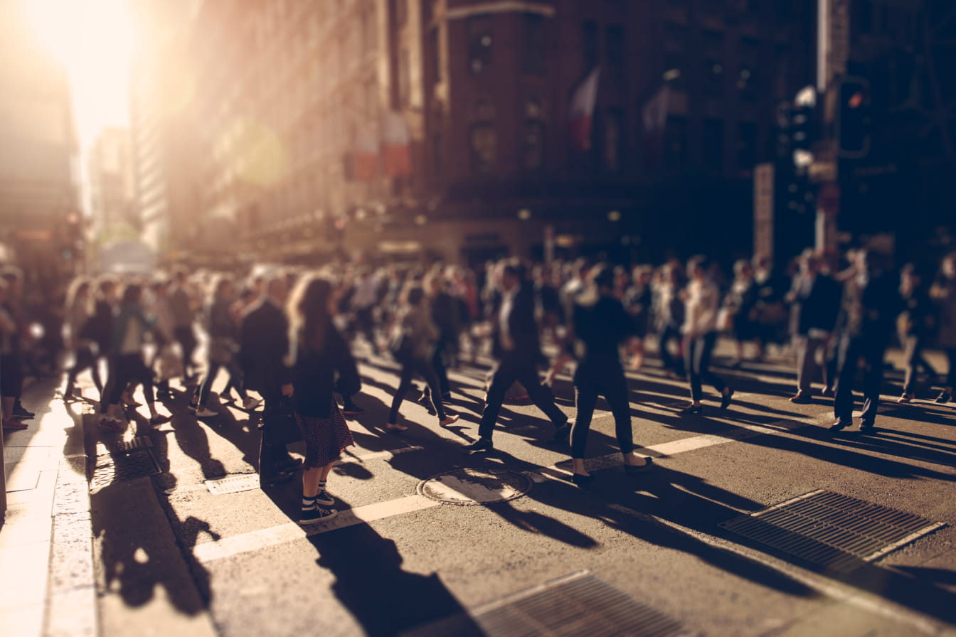 Crowd crossing a busy street, many out of focus